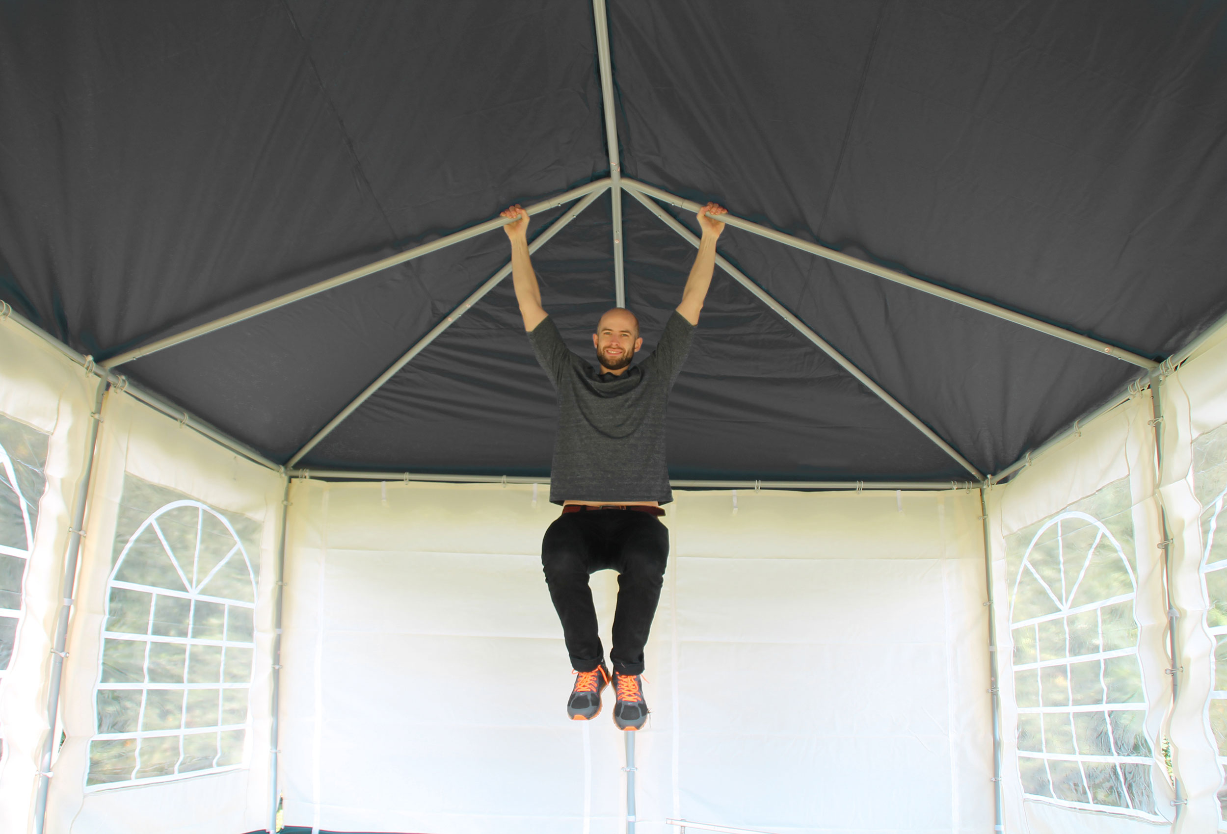 Belastungstest mit einer Person an einem Gestänge eines Gartenpavillons