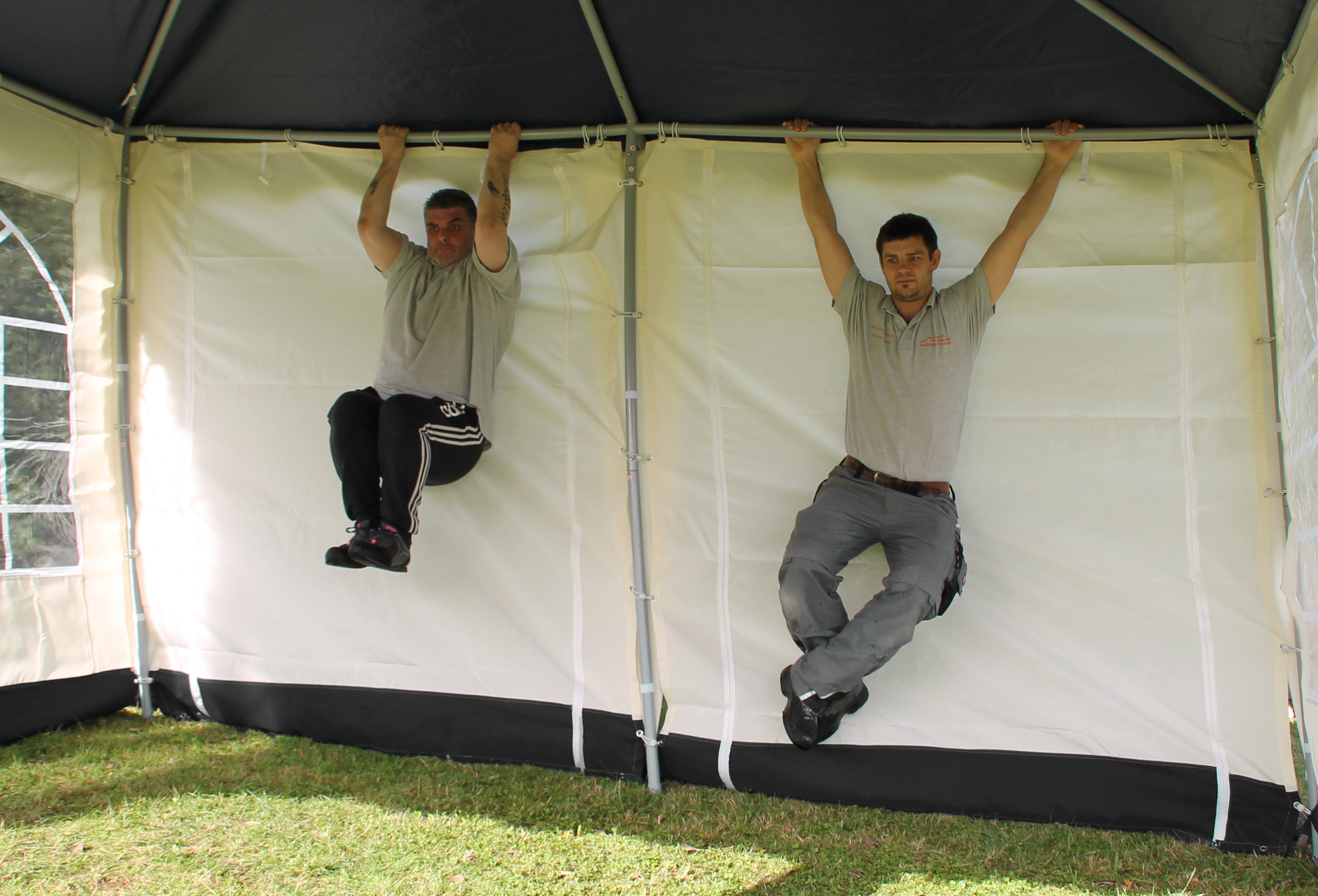 Belastungstest mit zwei Personen am Gestänge eines Gartenpavillons